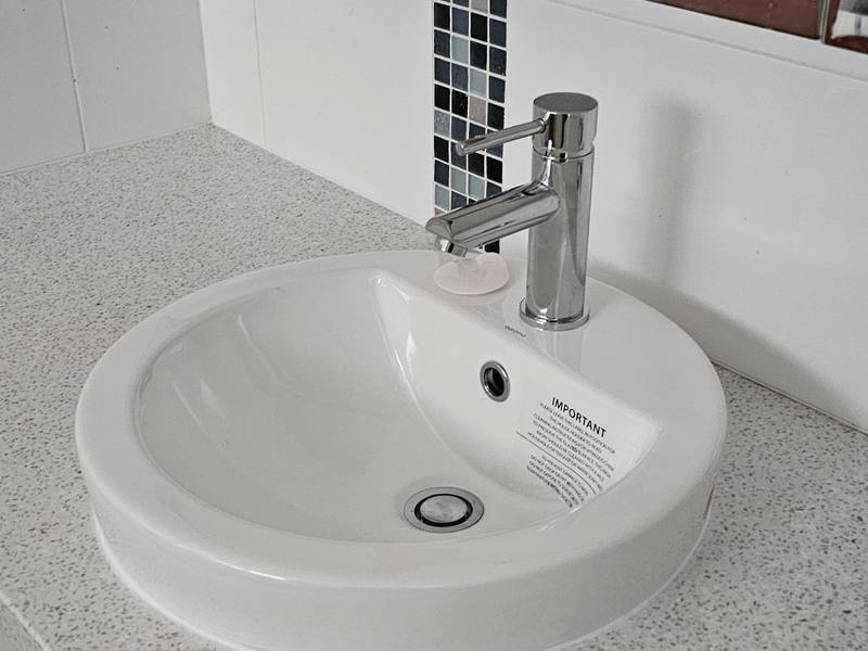 A replaced bathroom basin and mixer tap on a stone vanity