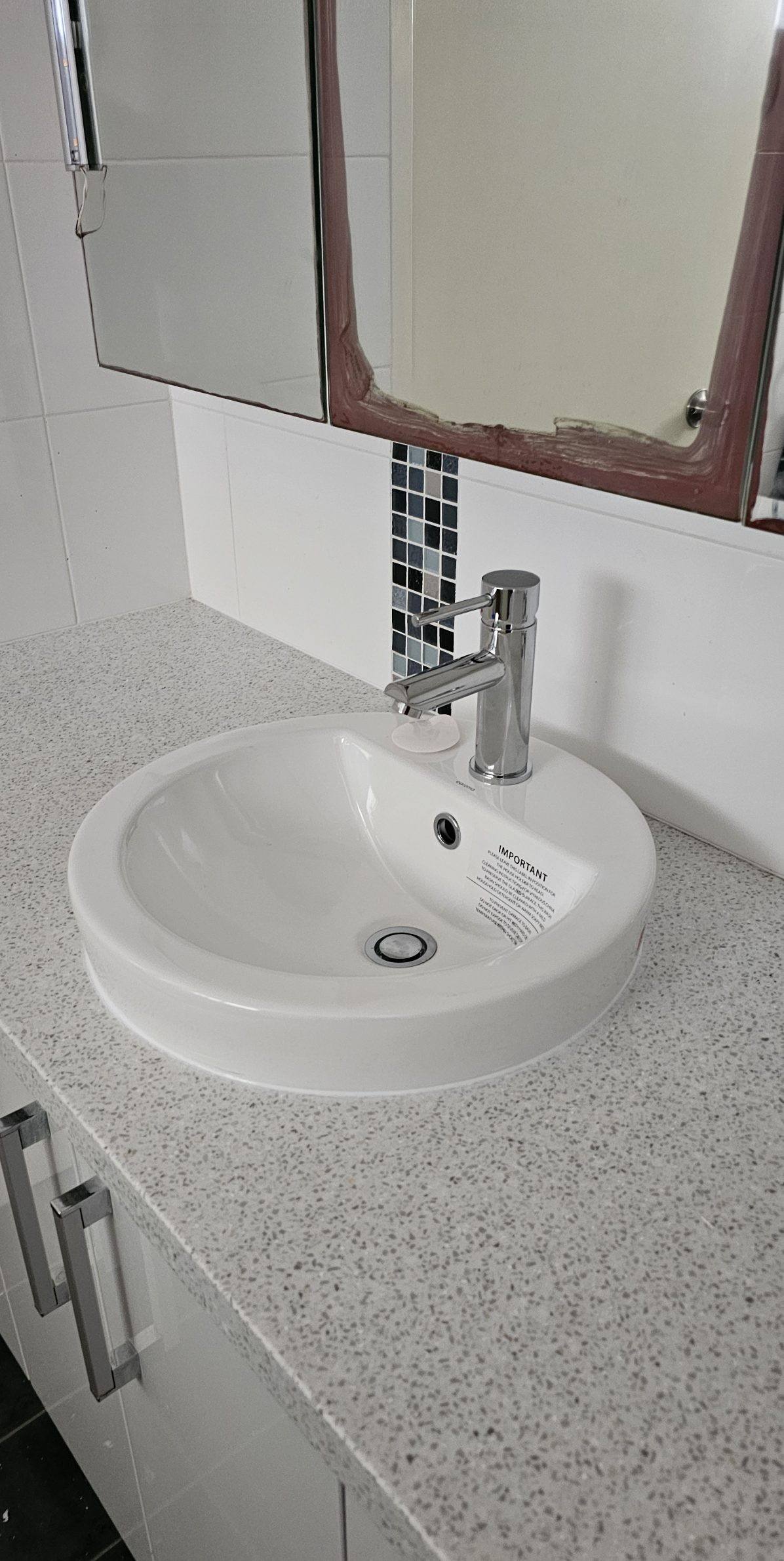 A replaced bathroom basin and mixer tap on a stone vanity