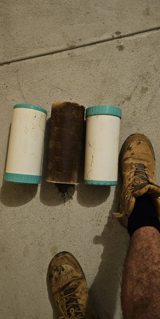 Three used whole-house filter cartridges on concrete after a filter change
